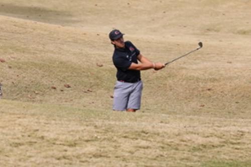 Student hitting golf tee